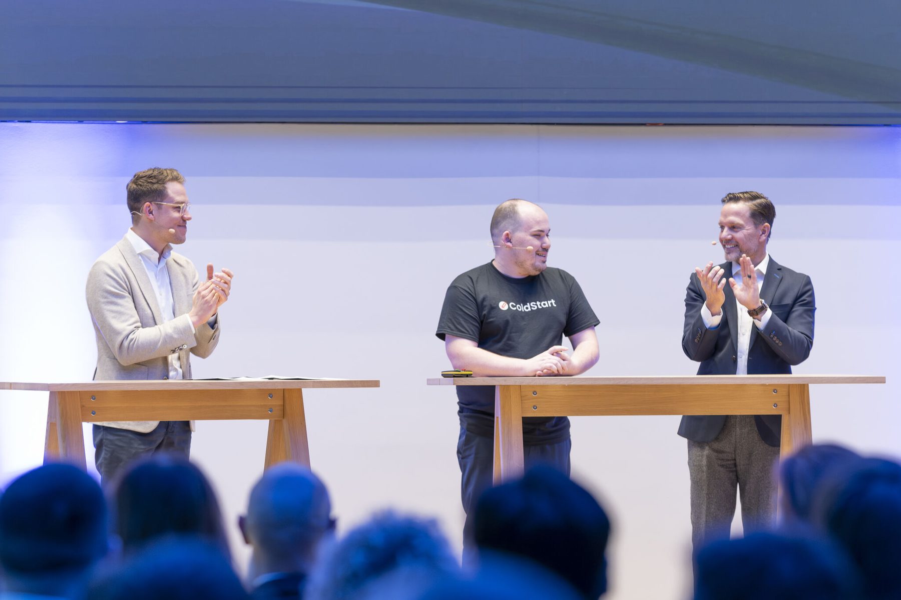 Brandon Teller on stage in a ColdStart shirt being applauded after winning the Plug and Play Innovation Challenge